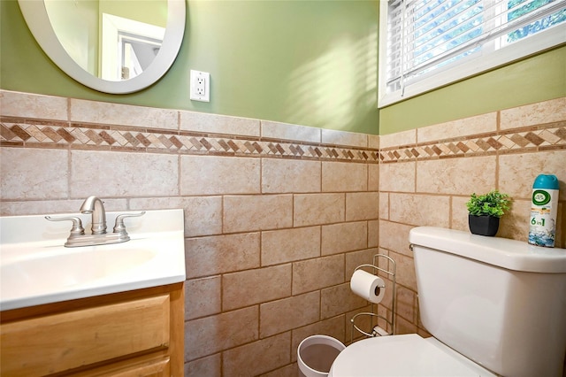 bathroom with vanity, toilet, and tile walls