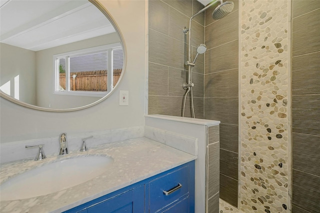 bathroom featuring a tile shower and vanity