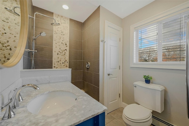 bathroom with vanity, tile patterned floors, toilet, tiled shower, and a baseboard radiator