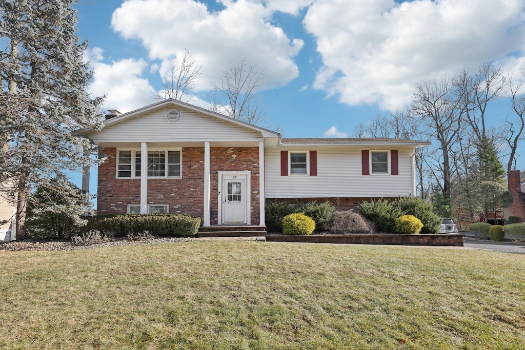 split foyer home with a front lawn