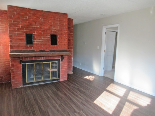 unfurnished living room with a fireplace and dark hardwood / wood-style flooring