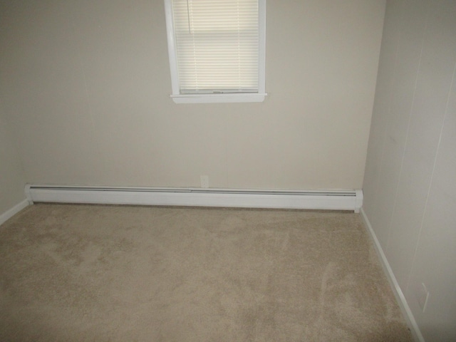 spare room featuring light carpet and a baseboard radiator