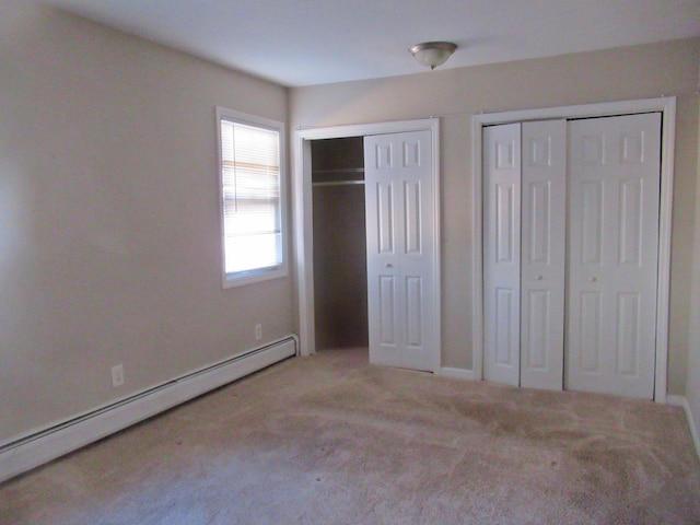 unfurnished bedroom featuring two closets, light colored carpet, and a baseboard radiator