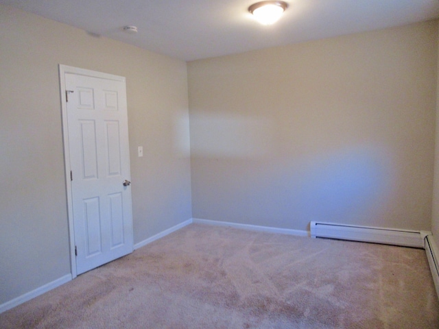 carpeted spare room featuring baseboard heating