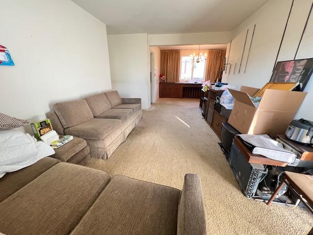 living room featuring light carpet and a chandelier