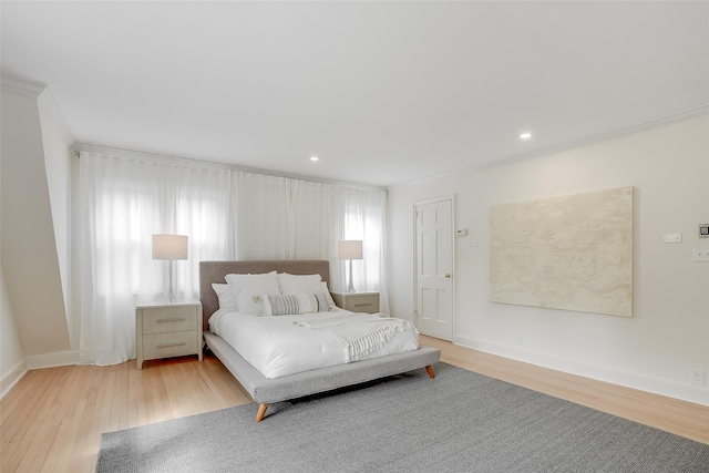bedroom with baseboards, recessed lighting, crown molding, and wood finished floors