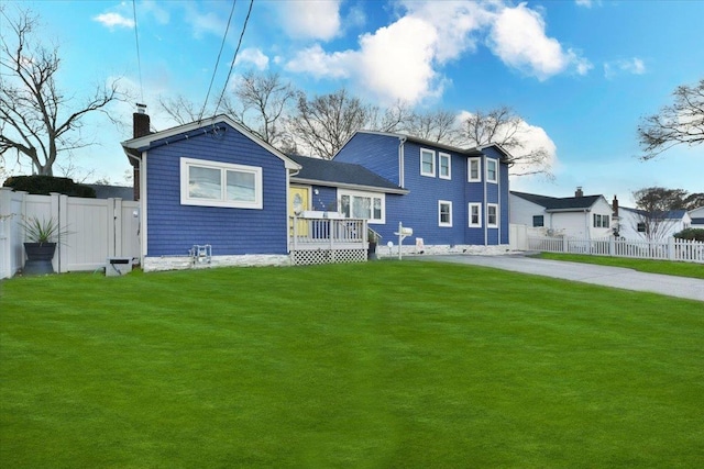 back of house with a wooden deck and a yard