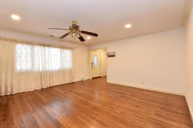 spare room featuring ceiling fan, wood-type flooring, and crown molding