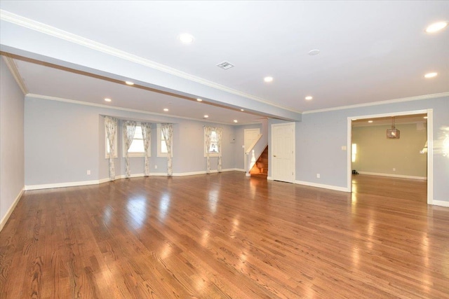 unfurnished living room with hardwood / wood-style flooring and crown molding