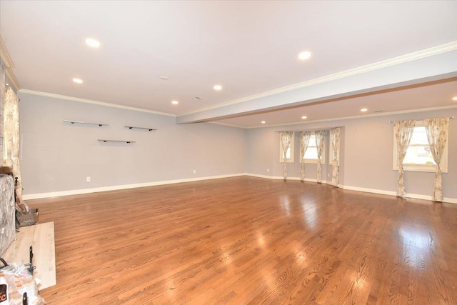 unfurnished living room featuring plenty of natural light, light wood-type flooring, and ornamental molding