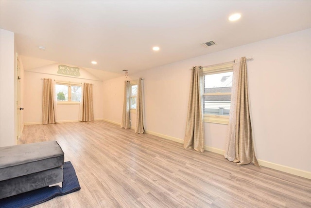 unfurnished room featuring light hardwood / wood-style floors and vaulted ceiling