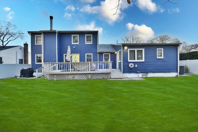 rear view of house with a lawn and a wooden deck