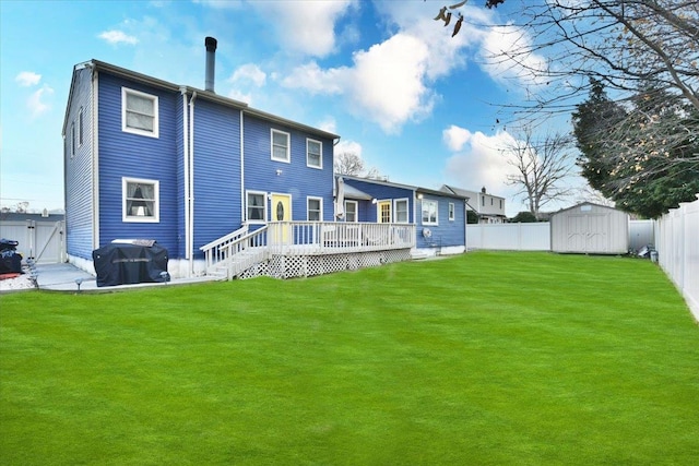 rear view of property with a shed, a deck, and a lawn