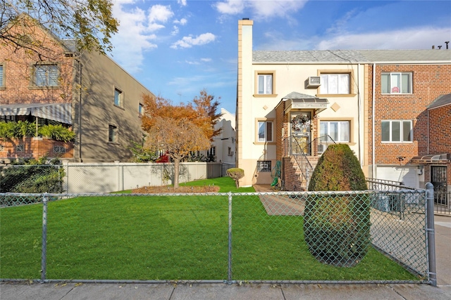 view of front facade with an AC wall unit and a front lawn