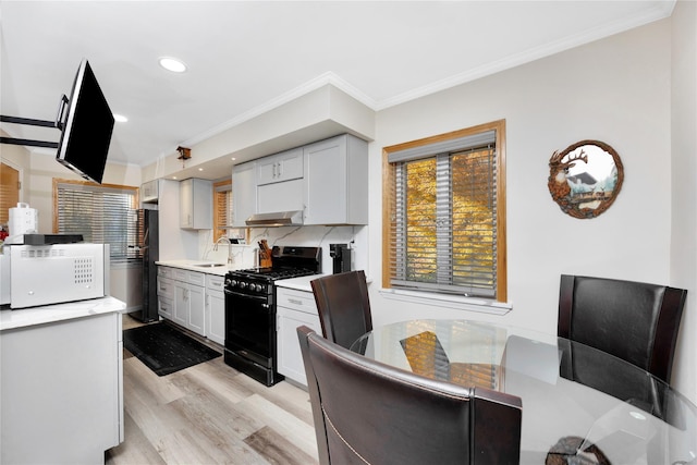 kitchen with sink, ornamental molding, and black appliances