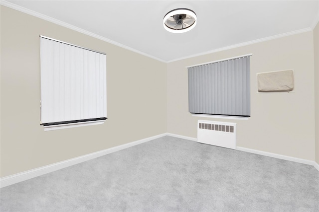 spare room featuring crown molding, radiator heating unit, and light carpet