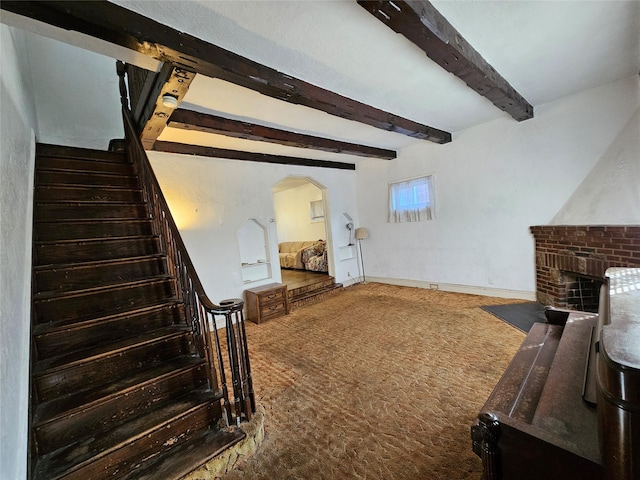 living room featuring carpet, a fireplace, and beamed ceiling