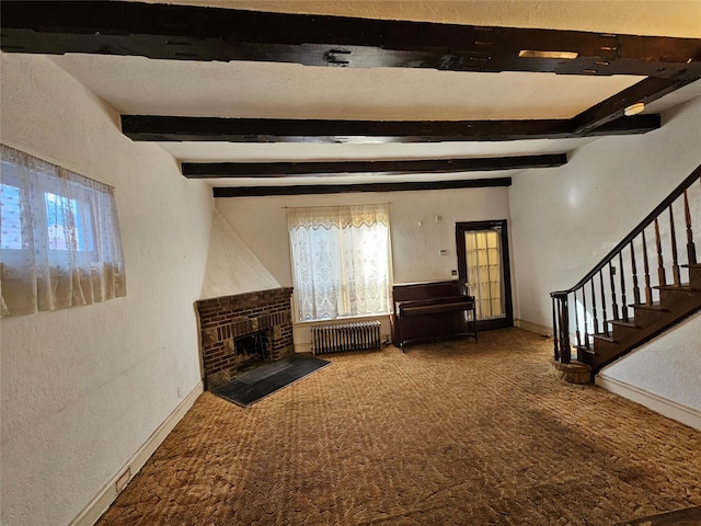 unfurnished living room with radiator, a wealth of natural light, carpet, and a brick fireplace