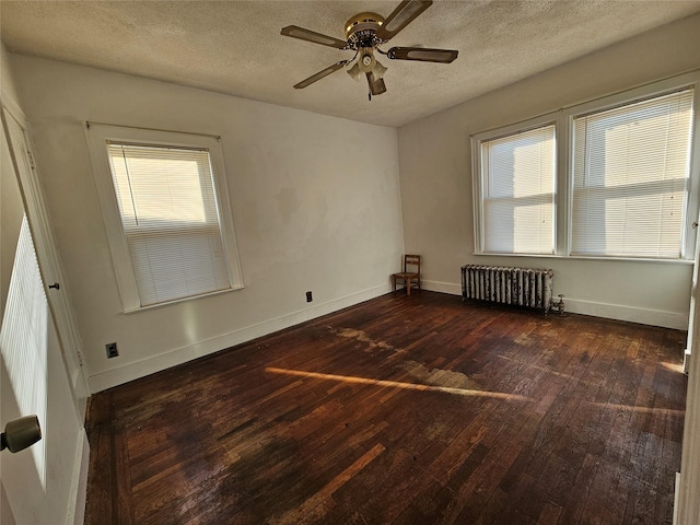 empty room with radiator heating unit, dark hardwood / wood-style flooring, a textured ceiling, and ceiling fan