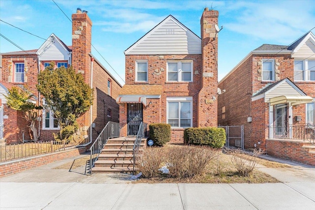 view of front of home with brick siding and fence