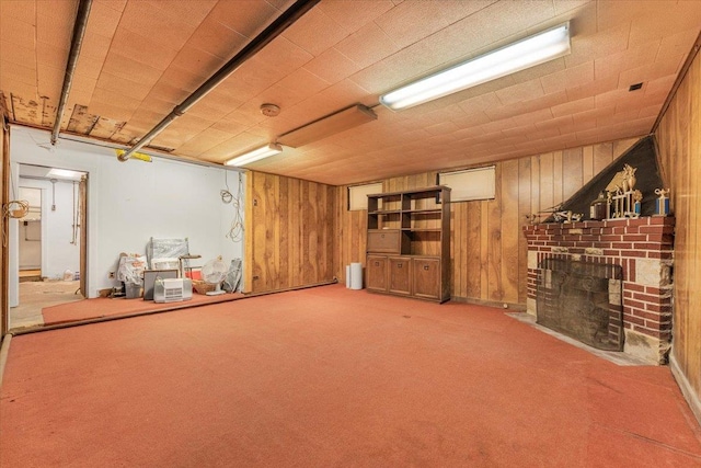 interior space with carpet floors, a fireplace, and wooden walls