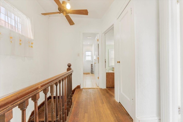 hallway with wood finished floors and an upstairs landing