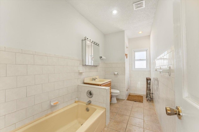 bathroom with tile walls, visible vents, toilet, a textured ceiling, and tile patterned floors