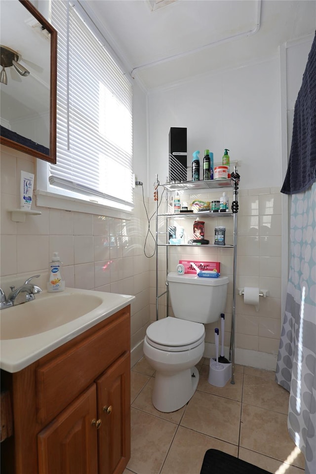 bathroom featuring tile patterned flooring, vanity, tile walls, and toilet