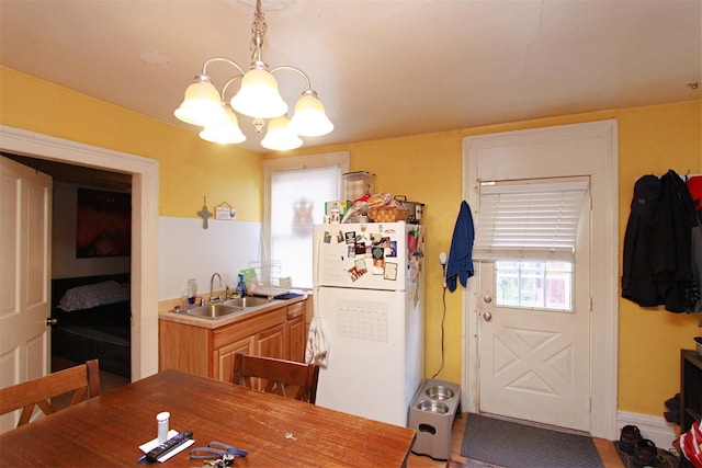 dining space featuring sink, plenty of natural light, and a notable chandelier