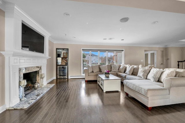 living room with crown molding, a fireplace, a baseboard radiator, dark hardwood / wood-style flooring, and beverage cooler