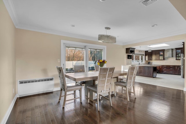 dining area featuring dark hardwood / wood-style flooring, radiator, and ornamental molding