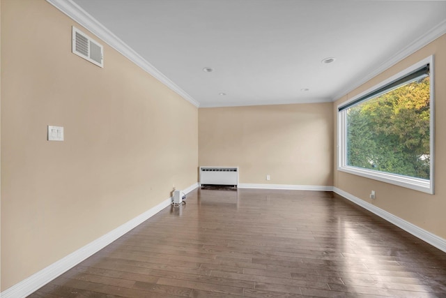 empty room with dark hardwood / wood-style flooring, crown molding, and radiator