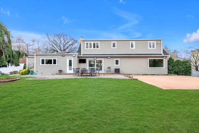 back of property featuring a lawn and a patio area