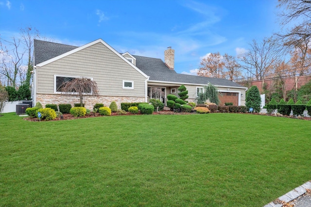 view of front of home with a front yard, a garage, and central AC unit