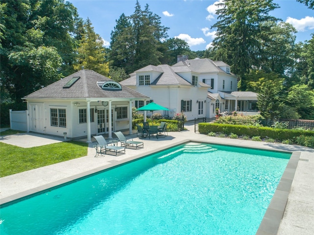 view of pool featuring an outbuilding and a patio area