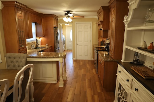 kitchen featuring appliances with stainless steel finishes, ceiling fan, sink, kitchen peninsula, and hardwood / wood-style flooring