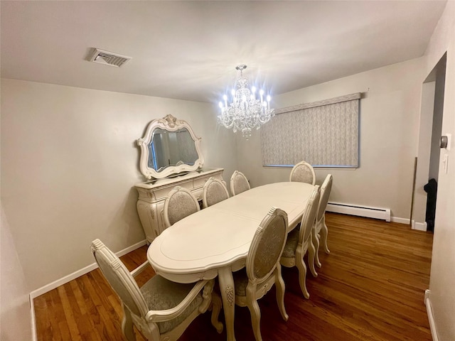 dining area featuring dark wood-type flooring, an inviting chandelier, and a baseboard heating unit