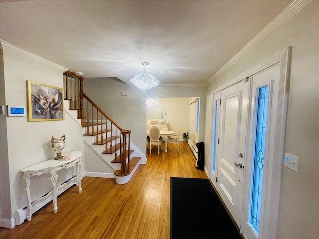 entryway featuring a chandelier, wood-type flooring, and ornamental molding