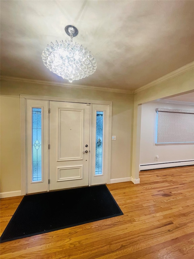 foyer entrance with light wood-type flooring, baseboard heating, a chandelier, and ornamental molding