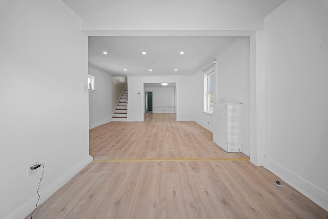 empty room with vaulted ceiling and light wood-type flooring