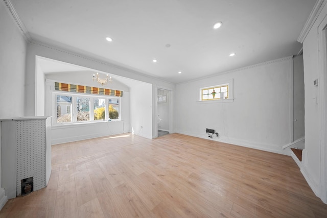 unfurnished living room with crown molding, a notable chandelier, and light hardwood / wood-style floors