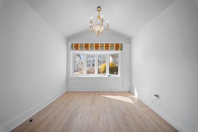 unfurnished dining area featuring lofted ceiling, a chandelier, and light wood-type flooring