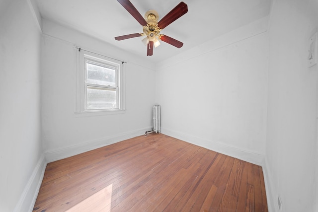 empty room with ceiling fan, radiator heating unit, and light wood-type flooring