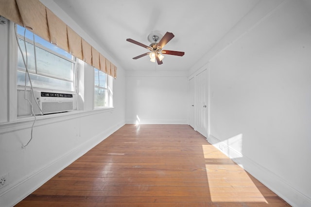 spare room featuring cooling unit, ceiling fan, and light hardwood / wood-style flooring