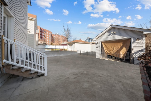 view of patio featuring a garage and an outbuilding