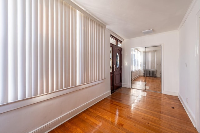 hallway with hardwood / wood-style floors and ornamental molding