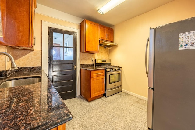 kitchen featuring backsplash, dark stone countertops, sink, and stainless steel appliances