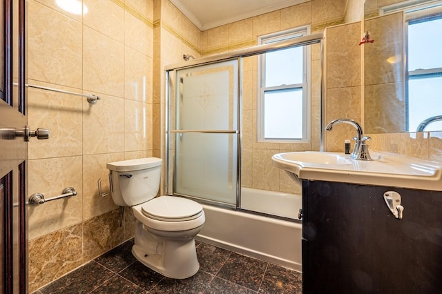 full bathroom with combined bath / shower with glass door, toilet, a wealth of natural light, and tile walls