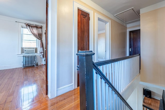 hallway with hardwood / wood-style floors, cooling unit, and radiator