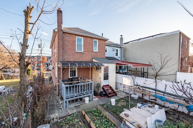 1059 Neill Ave, Bronx, NY 10461 - back of property with a garden, entry steps, brick siding, a chimney, and roof with shingles